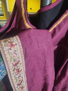 Dress hem with embroidered sari trim hem shown over the bodice with a pleated narrow satin ribbon neckline tirm.